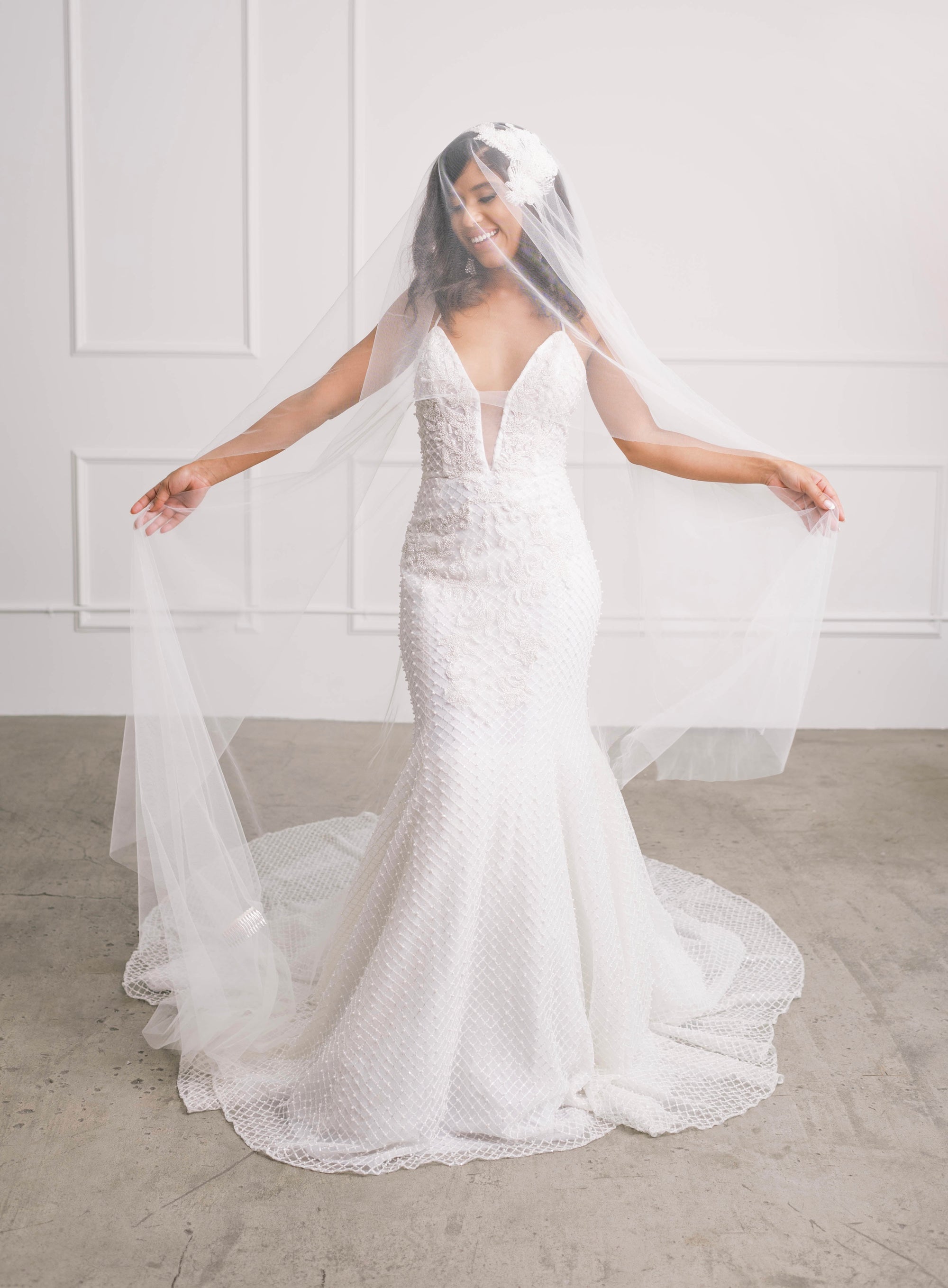 Beautiful bride wearing ivory wedding gown with statement pearl & crystal beading and veil
