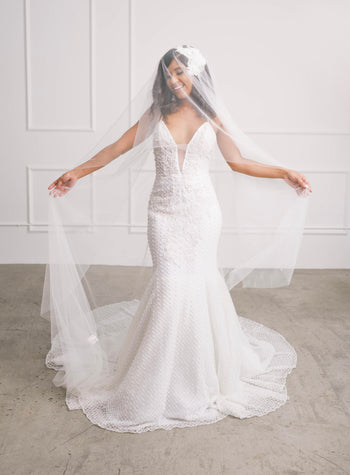 Beautiful bride wearing ivory wedding gown with statement pearl & crystal beading and veil