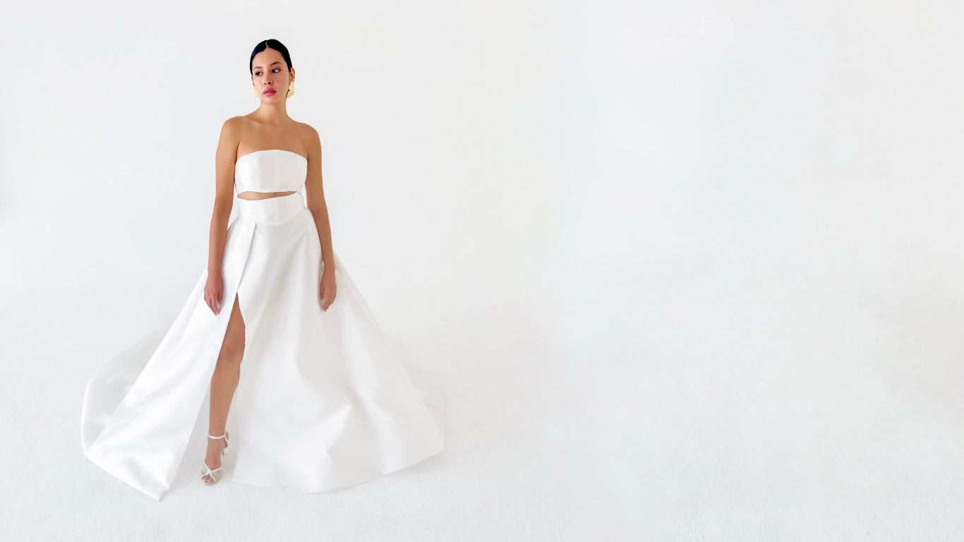 A beautiful Latina bride wearing a chic modern silk mikado a line wedding dress from the Lawrencia Bridal Couture Modern Matrimony Collection. The dress is a two piece crop top bridal separates look.