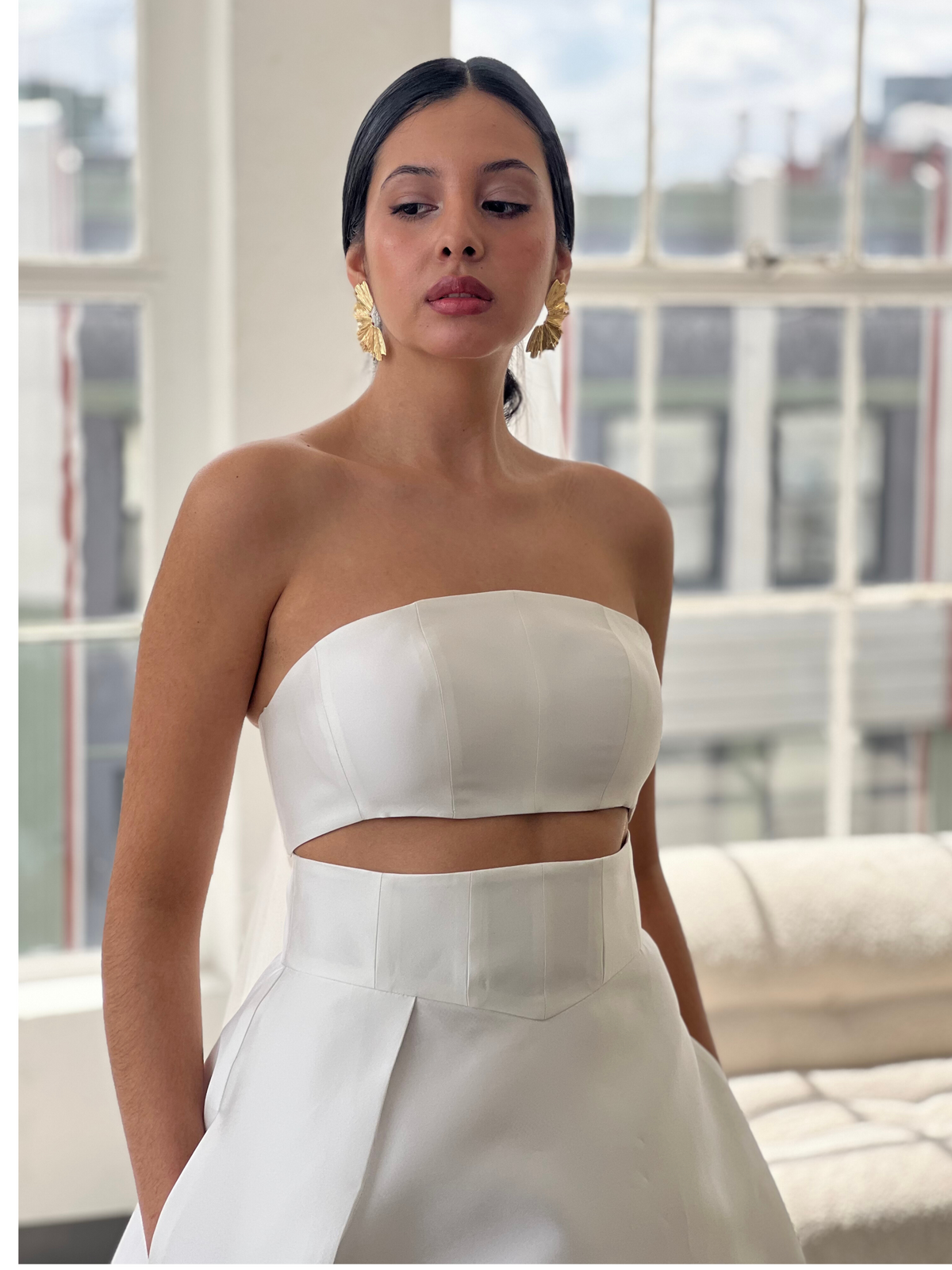 Close up photo of Latina bride wearing a two piece silk mikado wedding dress in Los Angeles black bridal Showroom