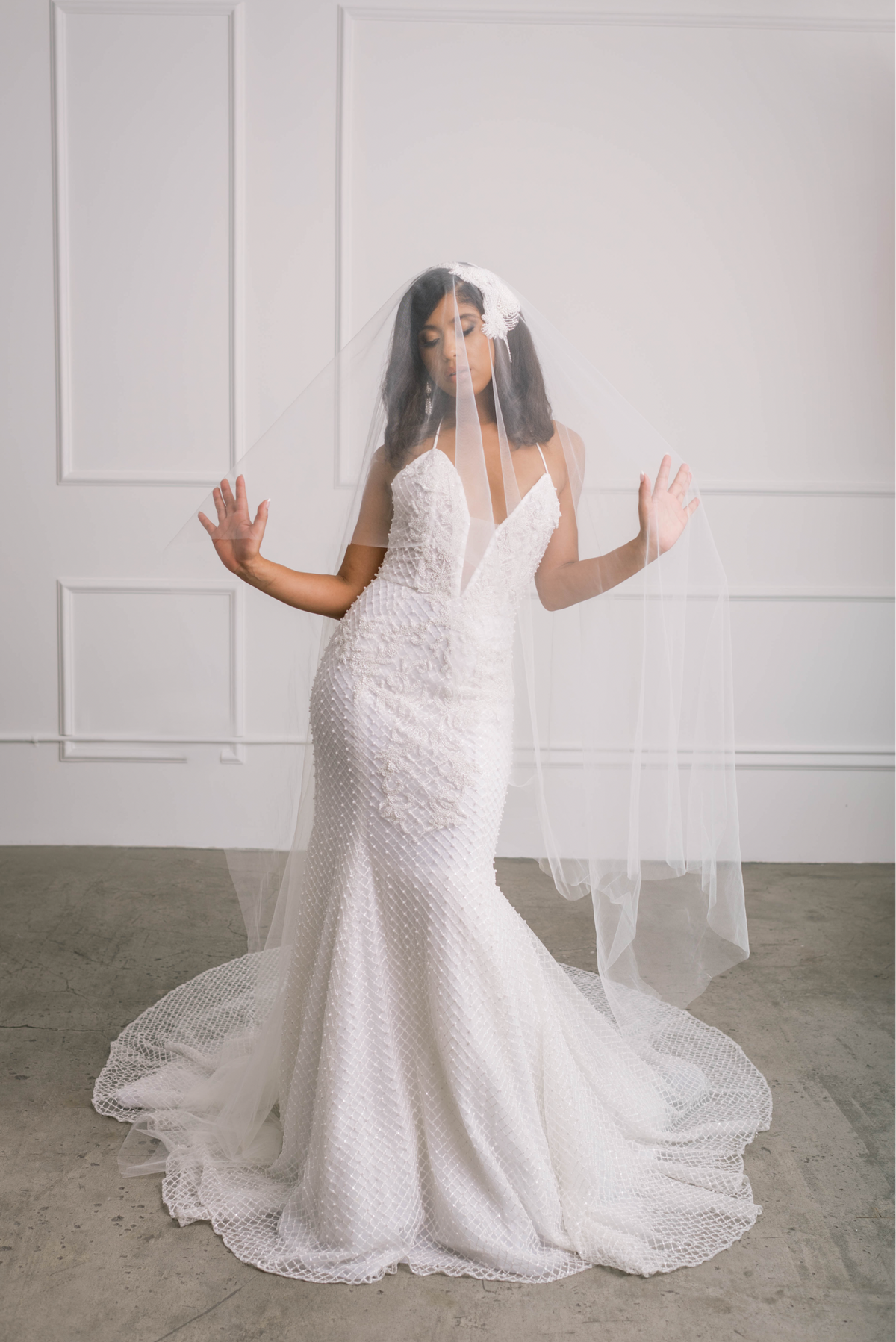 Beautiful bride wearing ivory wedding gown with statement pearl & crystal beading and veil