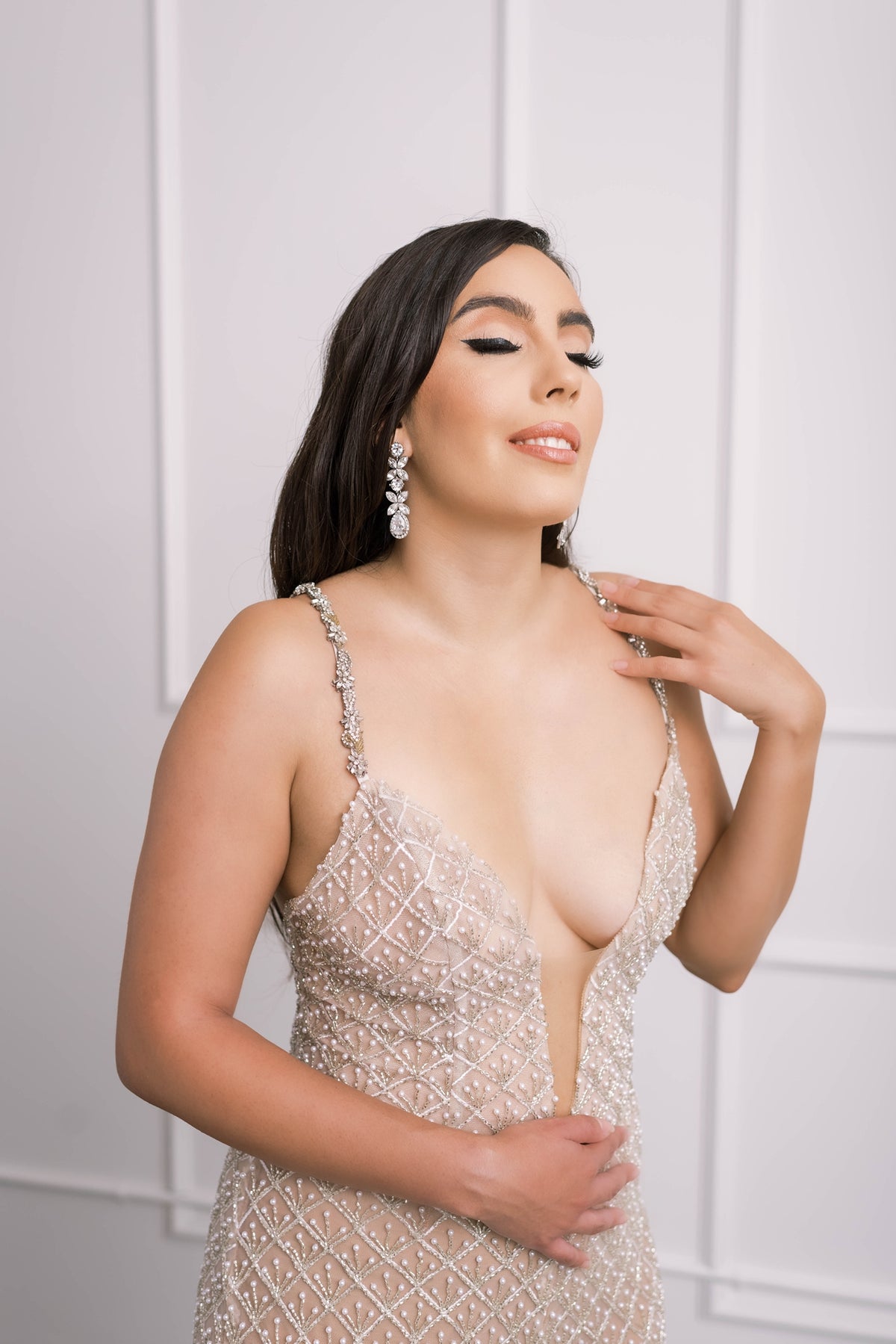 Smiling bride in sleek nude wedding jumpsuit with silver lace embroidery & crystal beading