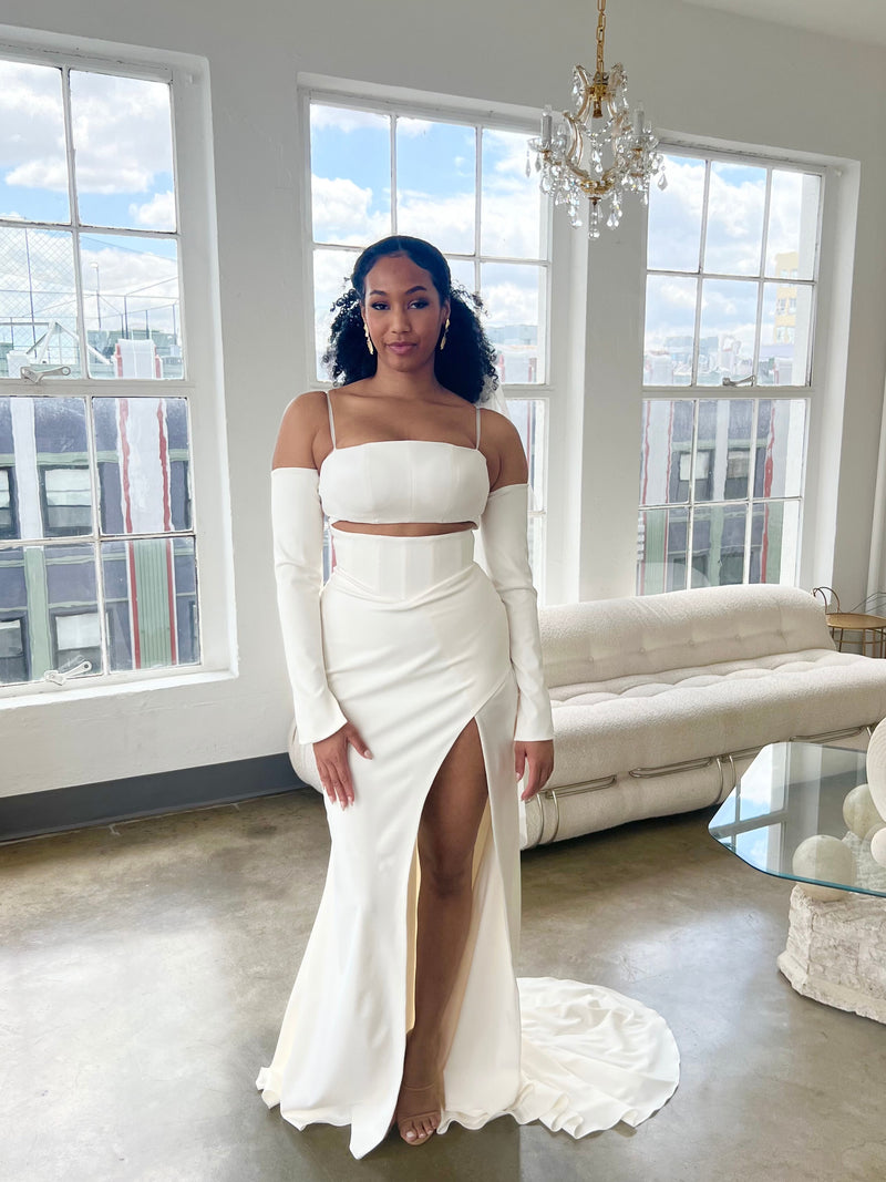 Black bride wearing black owned bridal brand Lawrencia Bridal Couture Modern stretch crepe two Piece wedding dress with detachable long sleeves inside of Downtown Los Angeles Bridal shop
