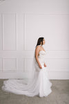 Side view of trumpet fit and flare wedding gown made of stretch satin with beaded choker cape