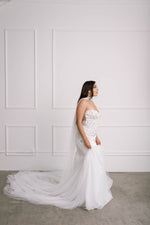 Side view of couture bride in mermaid bridal dress wearing daring wedding cape
