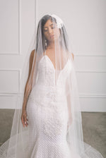 Sophisticated bride covered in wedding veil wearing a statement trumpet fit and flare bridal gown