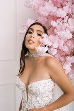 Modern bride wearing a statement cape, featuring a unique combination of crystals, rhinestones, and silver beads
