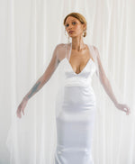 Bride displaying delicate veil in sophisticated classic mermaid gown