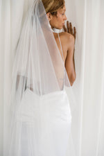 View of low open back wedding dress and elegant veil